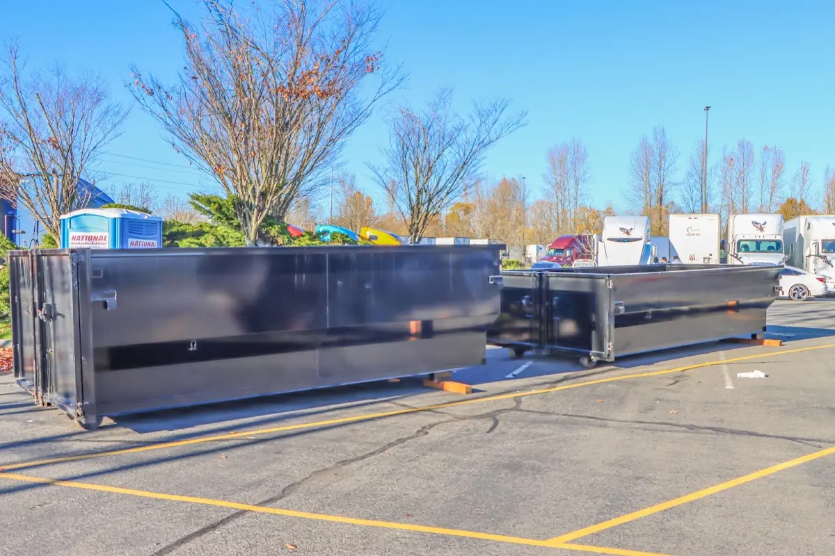 Professional dumpster rental service with roll-off container on residential driveway in Long Branch